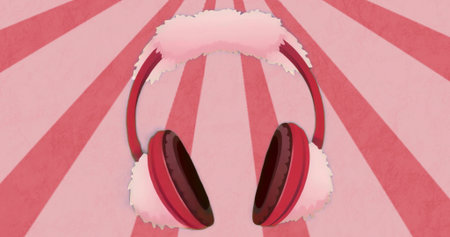 Showing over-ear earmuffs with red headband and fluffy pink padding on pink radial stripes. Headwear, fashion accessory, cozy, winter gear, plush, cute, stylishの写真素材
