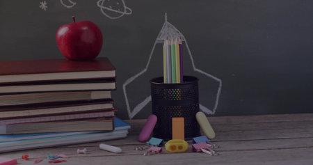 Holding colored pencils, pencil holder sitting in class with apple-topped textbooks and chalkboard....