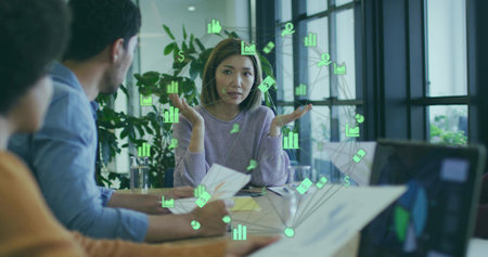 Woman in lavender top holding documents and gesturing in conference room, with laptop, icon overlay....