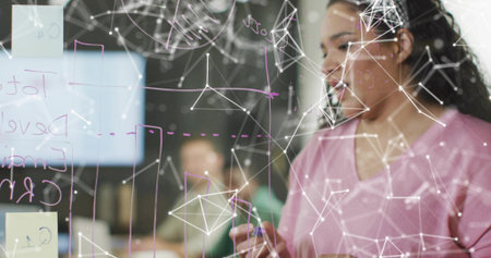 Marking woman wearing pink sweater drawing diagrams on whiteboard in conference room, copy space. Collaboration, teamwork, brainstorming, innovation, modern, professional, officeの写真素材