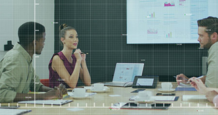 Four person business team reviewing charts on screen in conference room with laptops, speakerphone....