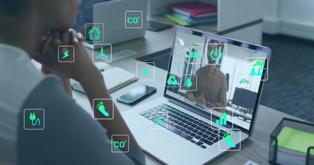 Male wearing business shirt listening during call at office desk, eco icons on laptop, copy space....
