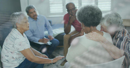 Comforting peers leaning around senior African American woman in living room, with clipboard....