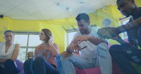 Sitting four colleagues discussing data in office lounge, with coffee cup, smartphone and pen....