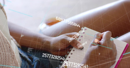 Woman taking notes with pen in pink-trim spiral notebook on living room sofa with digital overlay. Concentration, innovation, comfort, creativity, productivity, modern, lifestyleの写真素材