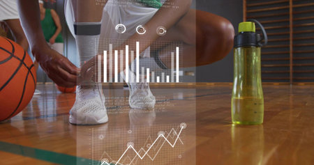 Tying sportswear-clad athlete lacing sneakers on gym court, with basketball and analytics overlay....
