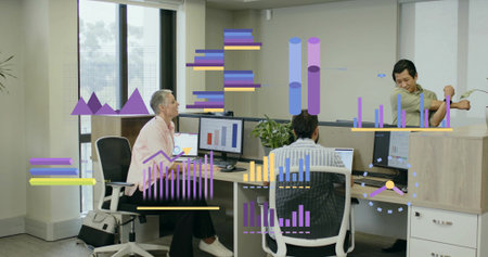 Collaborating coworkers in office attire reviewing graphs on monitors in open office, potted plant....