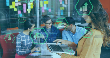 Leading businesswoman wearing mustard blazer holding laptop in office with sticky notes, copy space....
