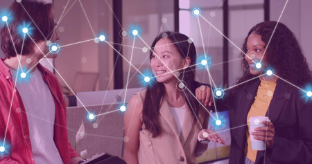 Discussing trio in business attire holding laptop in office lounge, with network overlay....