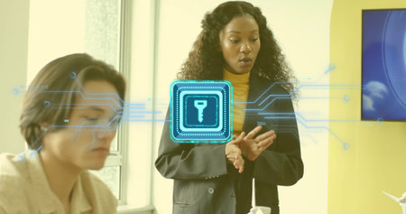 Presenting businesswoman in black blazer explaining encryption in office, with holographic key icon. Technology, cybersecurity, innovation, collaboration, corporate, futuristic, data protectionの写真素材