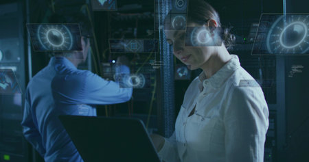 Reviewing engineer examining laptop in server room, holographic UI, network cables, copy space....