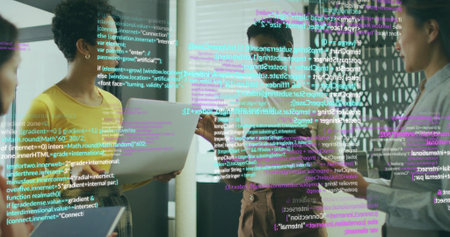 Collaborating women wearing shirts discussing code and data overlays in office area, with devices....