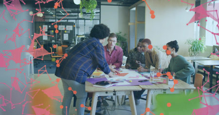 Pointing team members discussing design concepts around meeting table, with tablet and smartphone. Collaboration, brainstorming, innovation, team, creative, workspace, productivityの写真素材