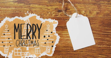 Image of merry christmas text over tag with copy space on wooden background. Christmas, tradition...