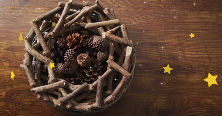 Image of stars over wreath with branches and cones on wooden background. Christmas, tradition and celebration concept digitally generated image.の写真素材