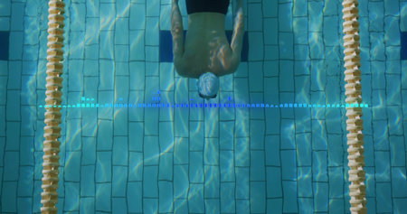 Gliding swimmer wearing swim cap pushing through pool lane, with dividers and marker overlay. Athletic, aquatic, competitive, fitness, exercise, performance, modernの写真素材