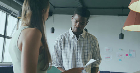 Reviewing documents man in plaid shirt consulting with teenage girl in modern office, sticky notes....