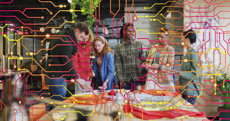 Collaborating colleagues arranging fabric swatches on table in design studio, with digital overlay. Creative, collaborative, workshop, innovative, industrial, colorful, modernの写真素材