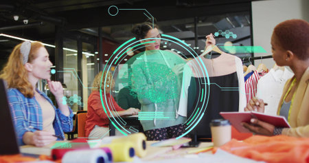 Collaborating design team presenting two-tone dress at fashion studio, with fabric rolls and laptop. Creative, teamwork, workspace, modern, industry, inspiration, collaborationの写真素材