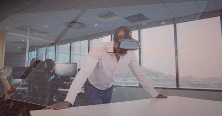Leaning forward African American man testing VR simulation at office conference table, with headset. Technology, innovation, collaboration, professional, futurism, productivity, modern designの写真素材