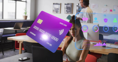Floating holographic bank card hovering above laptop on open-plan office desk, with financial icons. Futuristic, collaboration, technology, innovation, workspace, digital, professionalの写真素材