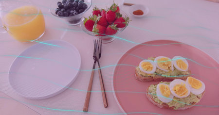 Displaying avocado toast topped with egg on pink plate at dining table, juice, berries, copy space. Healthy, brunch, rustic, vibrant, fresh, wellness, casualの写真素材