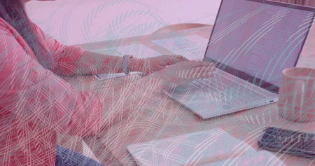 Asian Indian woman in pink top with colleague typing on silver laptop at home, copy space....