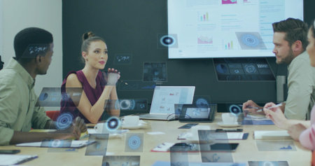Reviewing four professionals exploring 3D overlays in meeting room, with laptops and charts....