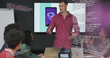 Presenting man in red shirt and jeans guiding colleagues at conference table, with app graphic. Collaboration, teamwork, office, technology, digital, innovation, discussionの写真素材