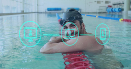 Resting swimmer wearing black cap, goggles on red lane divider at lap pool, with blue mats. Athlete, fitness, aquatic, training, serene, concentration, sportの写真素材