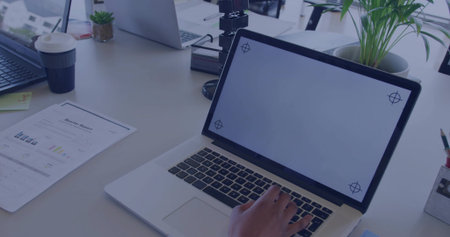 Typing worker hand pressing keys on primary laptop at white desk, with coffee cup, report, plants. Workspace, productivity, minimalism, modern, office, organization, technologyの写真素材