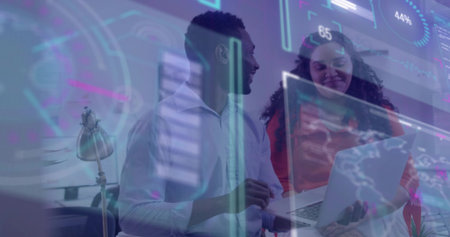 Reviewing data dashboards two colleagues collaborating on laptop in office with holographic chart. Data, collaboration, technology, innovation, analytics, interface, teamworkの写真素材