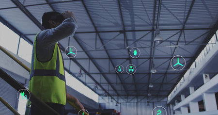 Scanning engineer viewing floating icons on steel stairs in warehouse, with safety vest, copy space. Industrial, progress, innovation, technology, infrastructure, urban, engineeringの写真素材