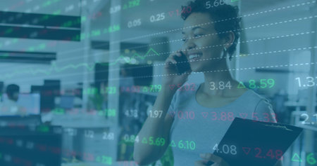 Speaking woman holding clipboard and smartphone in modern office, overlaid stock charts, copy space....