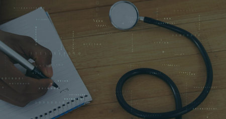 Writing hand holding black pen on lined notebook at desk, stethoscope, binary overlay, copy space. Medical, technology, professional, documentation, innovation, healthcare, productivityの写真素材
