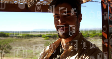 Male observing data icons on transparent glass panel under wooden beams in open-air pavilion. Corporate, technology, business, outdoor, modern, professional, innovationの写真素材