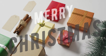 Merry Christmas text image over various wrapped gifts and holiday decorations. Celebration, festive,...