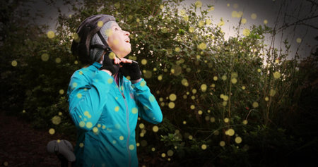 Fastening female cyclist securing chin strap on forest trail, with lens flare artifacts, copy space. Adventure, outdoor recreation, fitness, motion, nature, sport, environmentの写真素材