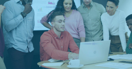 Working male in red shirt navigating silver laptop at conference room, display showing charts. Collaboration, teamwork, presentation, innovation, technology, business, analyticsの写真素材
