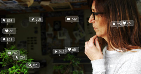 Reflecting woman in sweater studying collage, potted plants and social icons in studio, copy space....