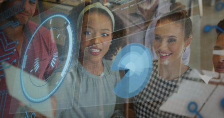 Leaning tech team of five pointing at glass panel at office, with holographic interface and tablet. Collaboration, innovation, technology, data, digital, futurism, teamworkの写真素材