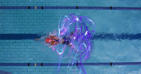 Swimming athlete wearing red cap, goggles, swimsuit between divider ropes in pool amid purple light. Aquatic, fitness, motion, futuristic, sport, hydration, enduranceの写真素材