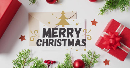 Merry Christmas text image over festive decorations with gifts and greenery. holiday, celebration, seasonal, greeting, winter, joyfulの写真素材