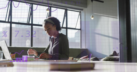Typing on laptop at office table, woman wearing blouse analyzing financial data overlay, copy space. Professional, modern, minimalistic, productivity, urban, digital, analyticalの写真素材