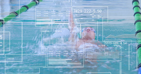 Gliding swimmer wearing cap, goggles performing backstroke in pool lane, with digital data overlays. Athlete, performance, aquatic, training, competitive, technology, fitnessの写真素材