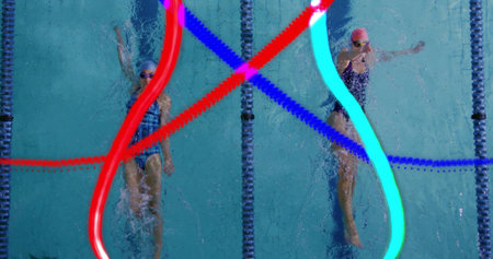 Gliding female swimmers performing backstroke at lap pool overhead, with neon trails, lane dividers. Aquatic, performance, dynamic, energy, movement, fitness, competitiveの写真素材