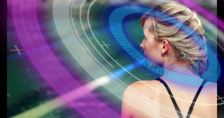 Observing female wearing sports top engaging with ring interface graphics over turf, copy space. Futuristic, technology, innovation, sport, digital, interface, performanceの写真素材
