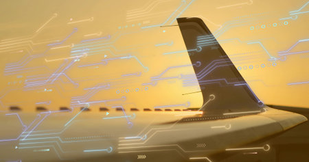 Displaying tail fin and wing through window at cruising altitude, with digital overlays, copy space. Aviation, technology, connectivity, sunset, digital, aircraft, aerialの写真素材