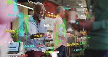 Holding coffee cup senior man sitting on white desk in open-plan office lounge, with laptop charts. Collaboration, innovation, professionalism, modernity, teamwork, workspace, communicationの写真素材