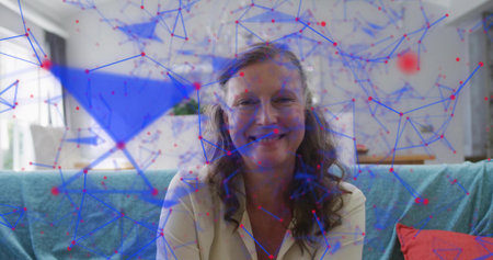 Sitting mature woman wearing light blouse on sofa in living room, with laptop and network overlay....